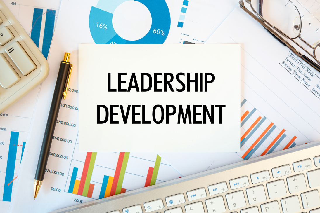 Leadership Development is written in a document on the office desk, diagram and keyboard